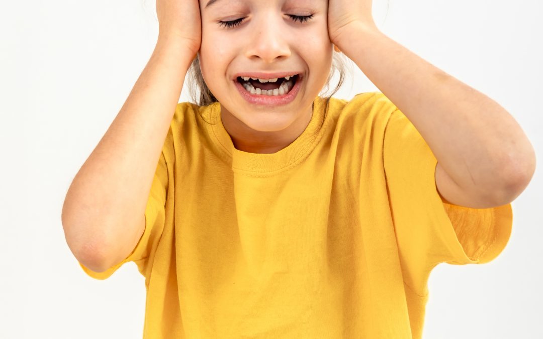 Fotografía de una niña mostrando signos visibles de estrés agudo y desregulación emocional, ilustrando la acumulación de tensión sensorial y cognitiva al final de una jornada escolar en niños con Síndrome de Asperger