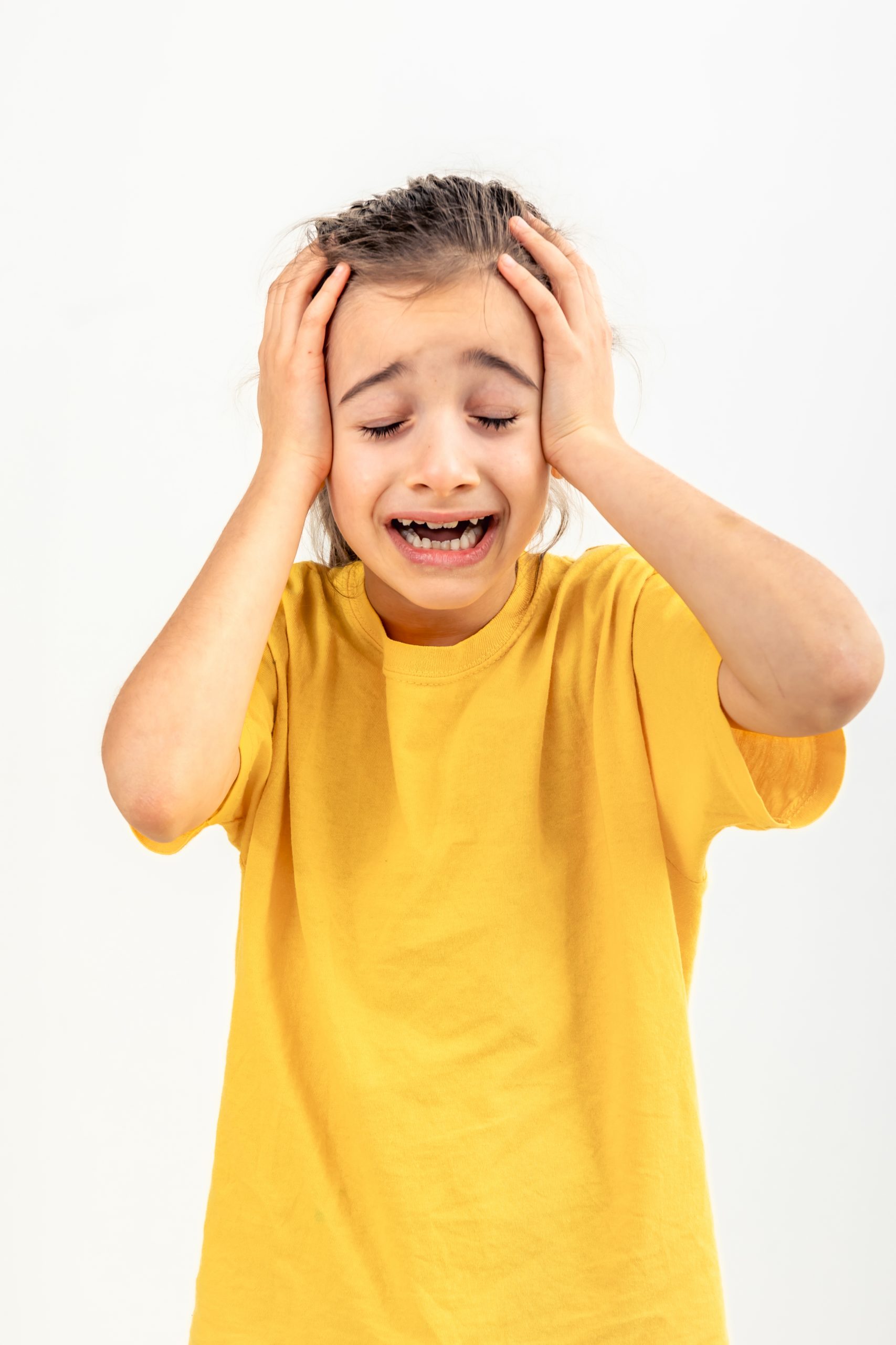 Fotografía de una niña mostrando signos visibles de estrés agudo y desregulación emocional, ilustrando la acumulación de tensión sensorial y cognitiva al final de una jornada escolar en niños con Síndrome de Asperger