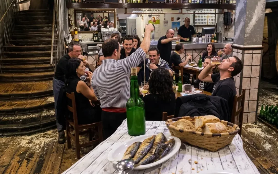 Interior de un chigre asturiano con personas compartiendo sidra escanciada, ejemplo de la cultura sidrera declarada Patrimonio Cultural Inmaterial de la Humanidad por la UNESCO.