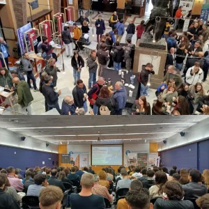 Asistentes en zona de exposición y conferencia en un congreso internacional